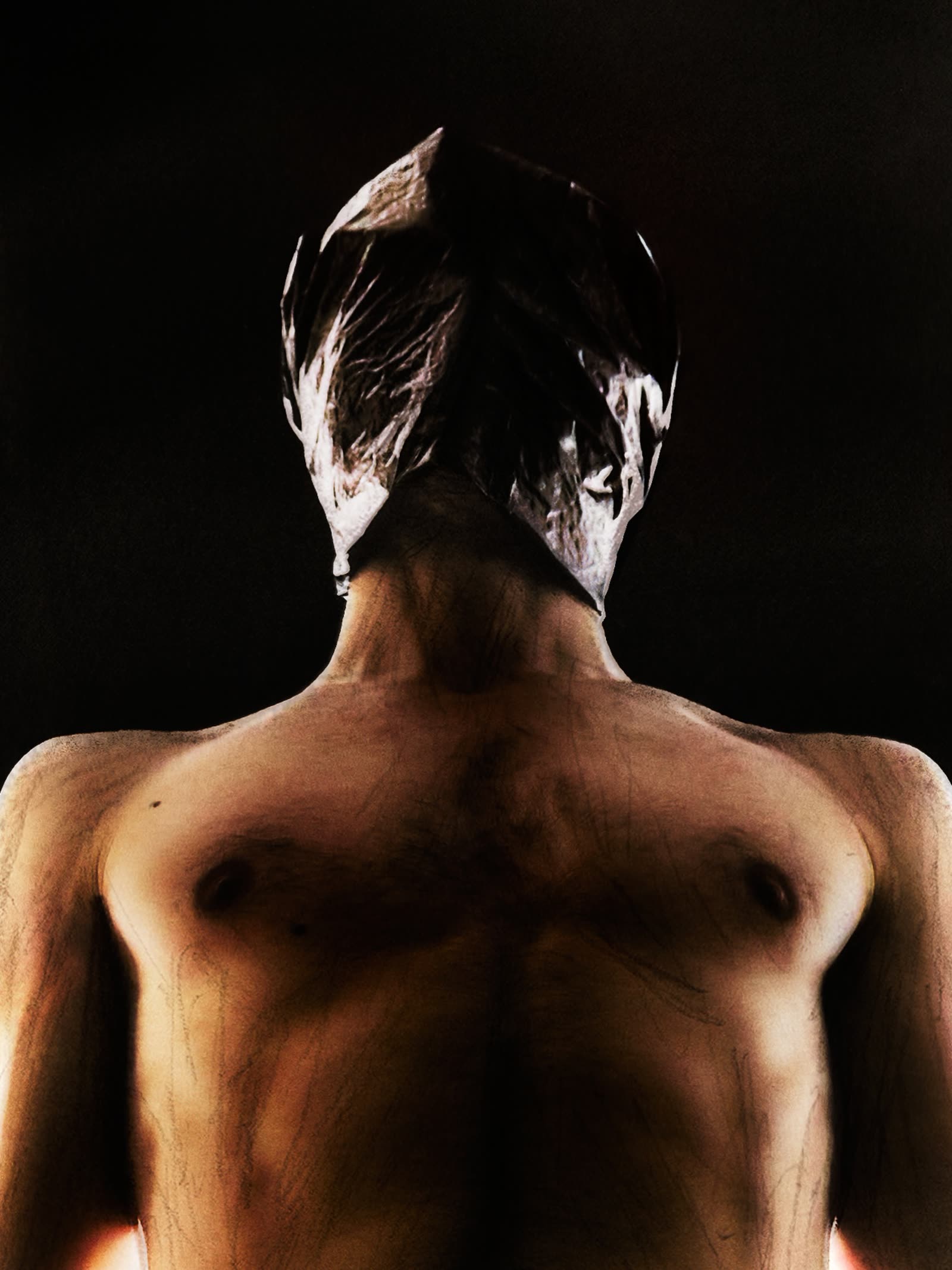 Low-key studio portrait, back turned to the light.